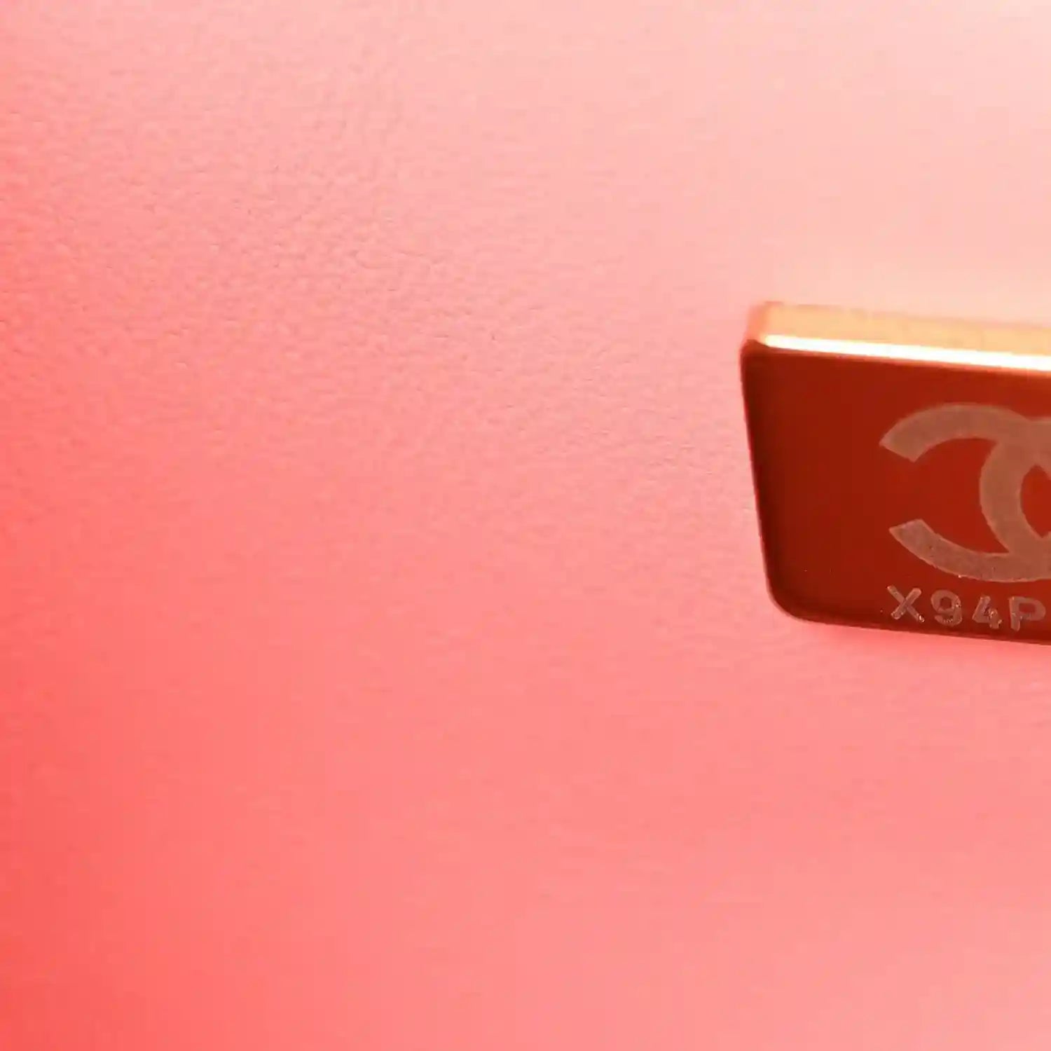CHANEL mark on gold-tone metal plaque attached to light pink leather