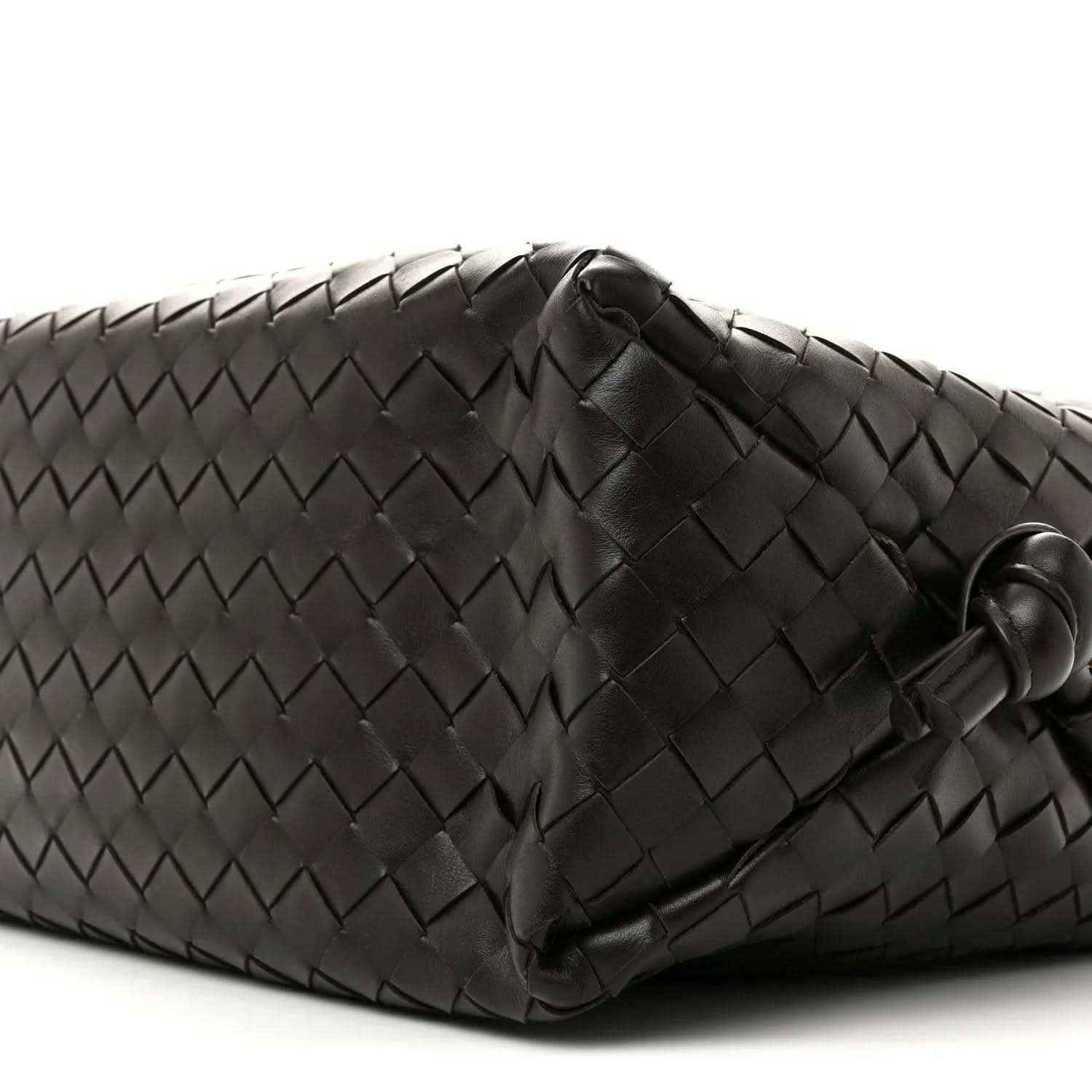 Black woven leather weekender bag corner with stitched detail and loop handle