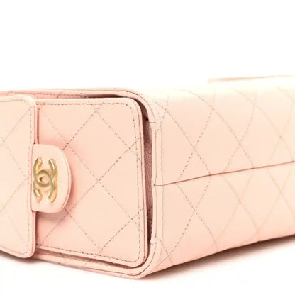 Light pink quilted mini handbag front with gold-tone Chanel logo on leather tab