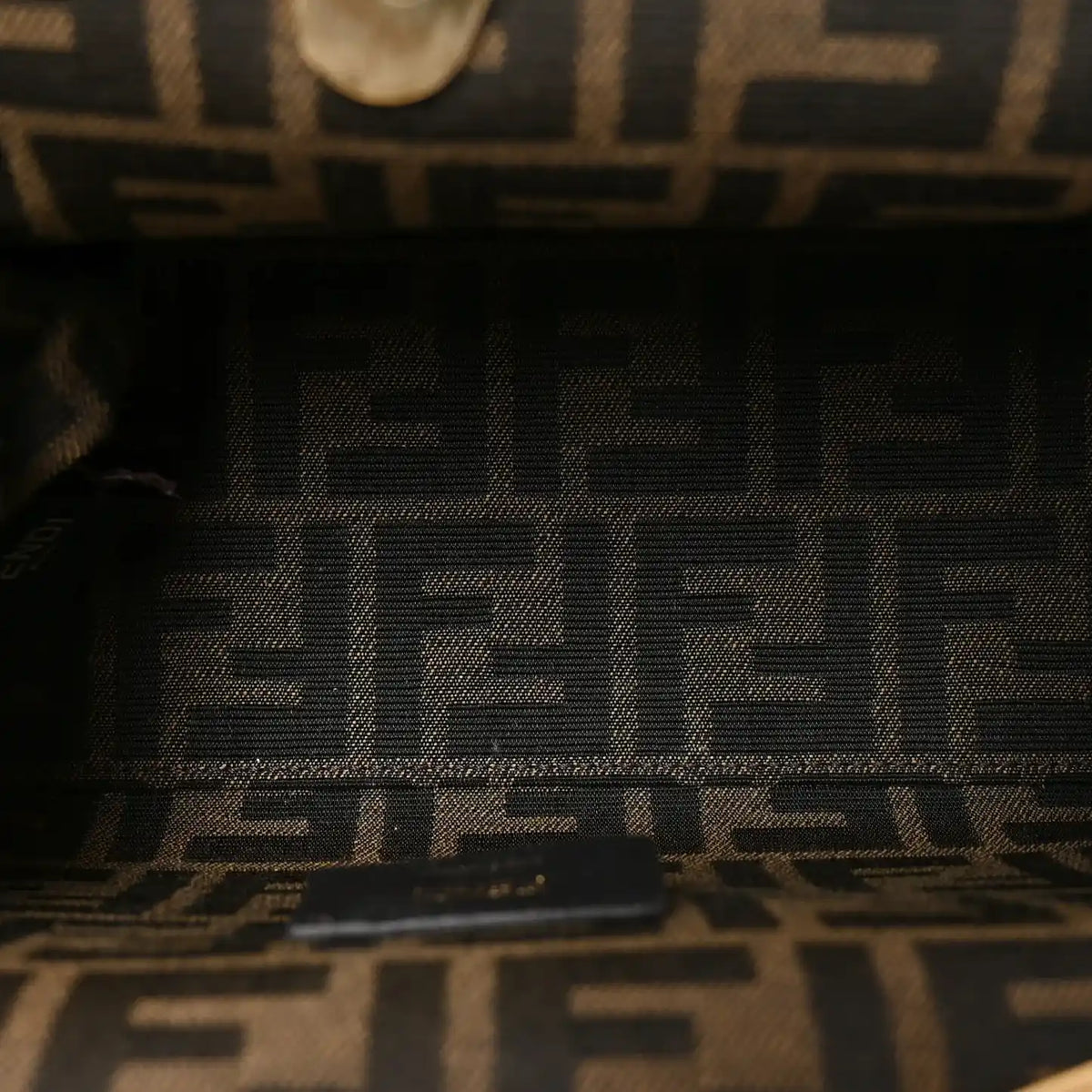 Black leather brand label with FENDI text on small shoulder bag