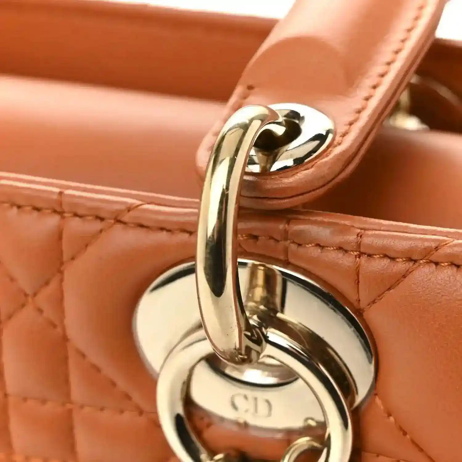 Small tote clasp with gold ring and Christian Dior emblem on orange lambskin