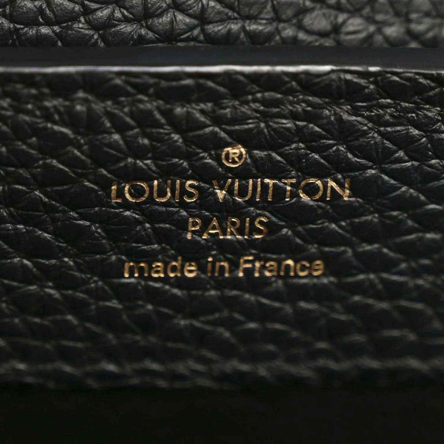 Close-up of black textured leather with Louis Vuitton PARIS made in France stamp