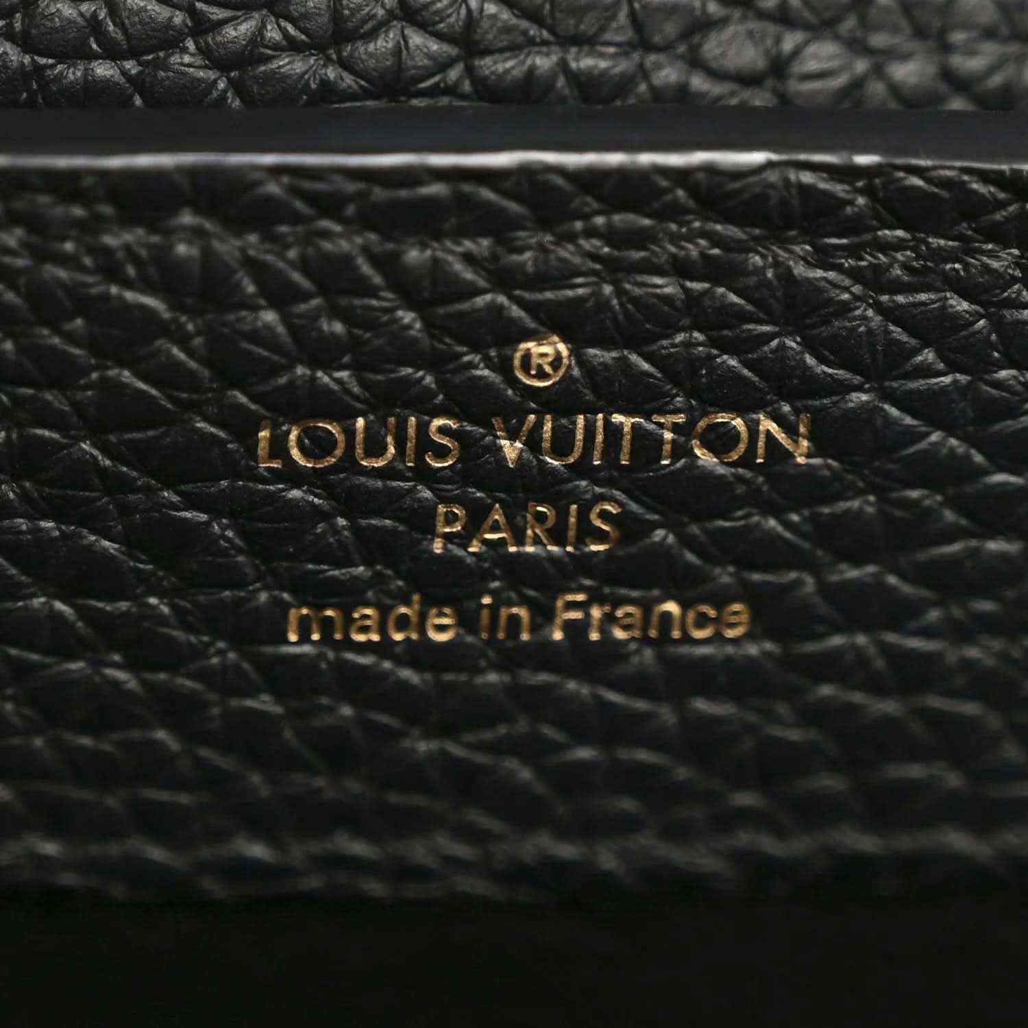 Close-up of black textured leather with Louis Vuitton PARIS made in France stamp