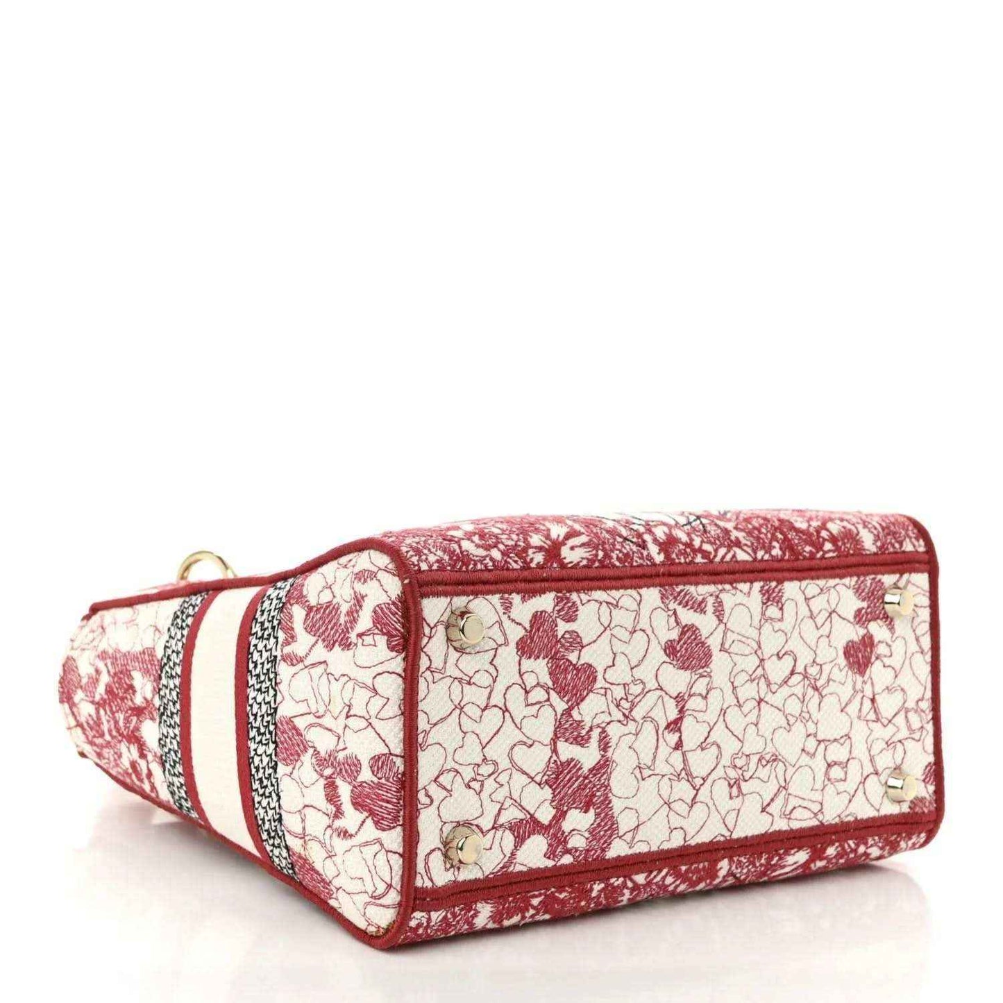 Embroidered canvas bag with red top trim, red-and-white heart pattern, short wrist strap.