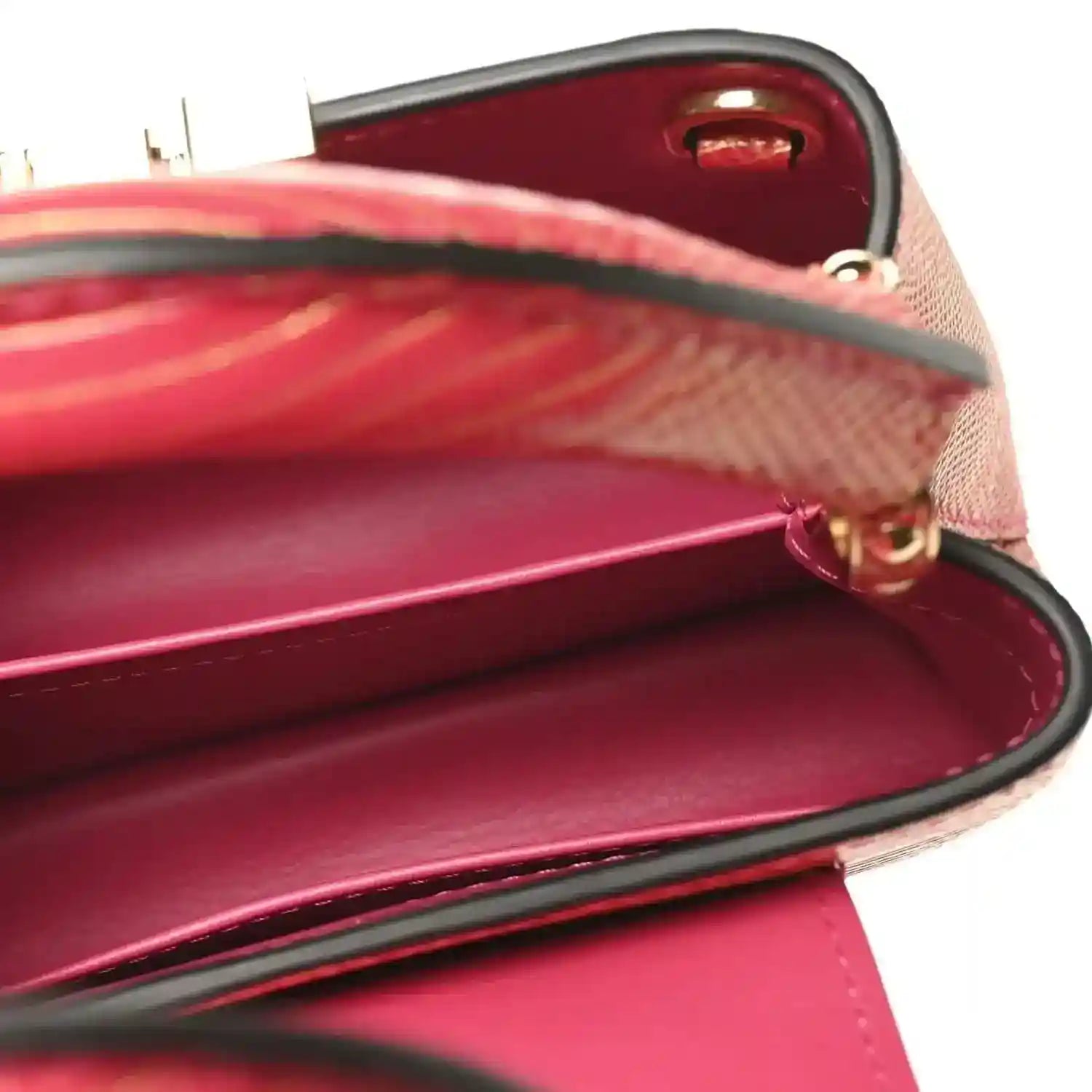 Louis Vuitton mini handbag open top close-up with red lining and gold trim.