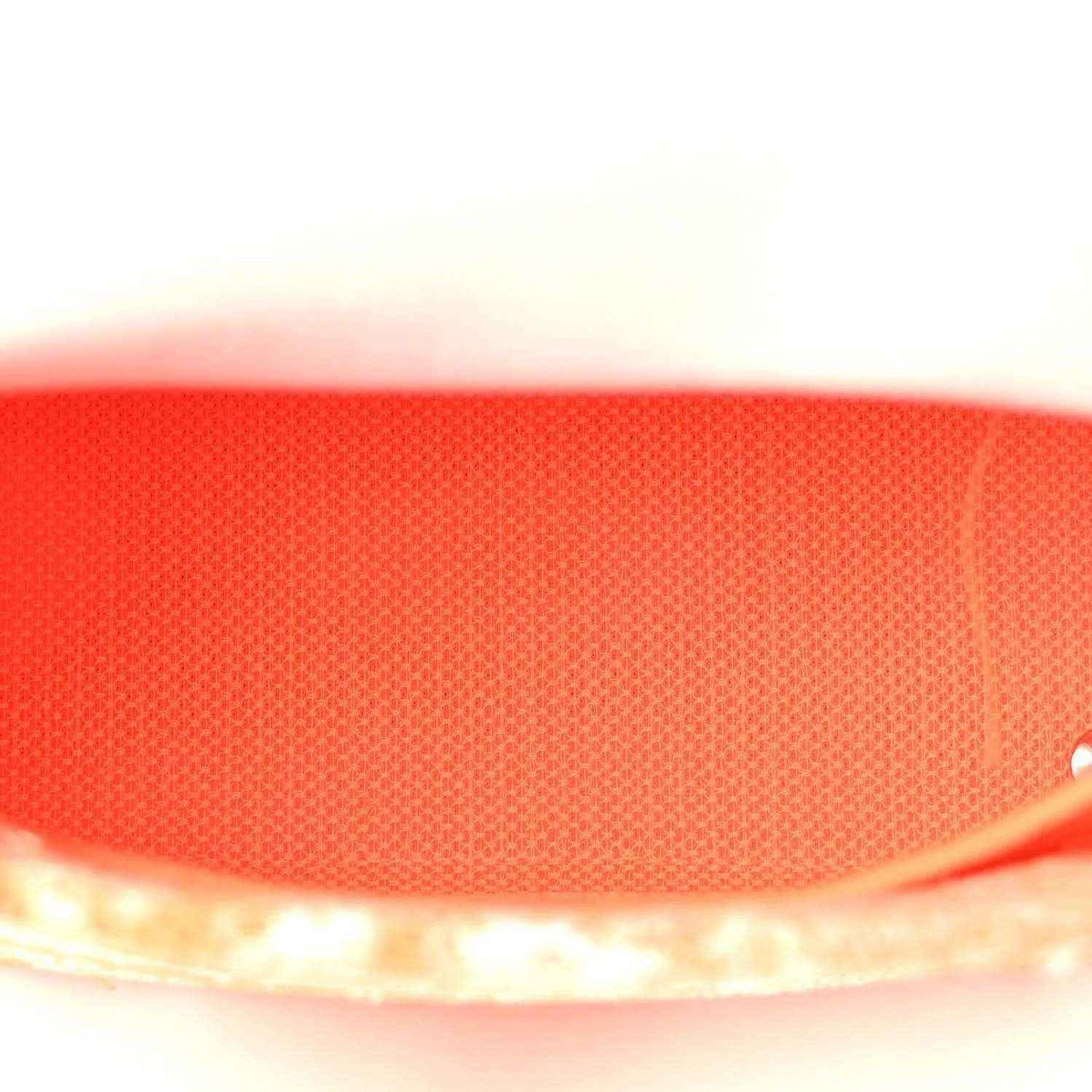 Orange textured fabric close-up of the bag panel with stitched edge trim.