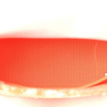Orange textured fabric close-up of the bag panel with stitched edge trim.