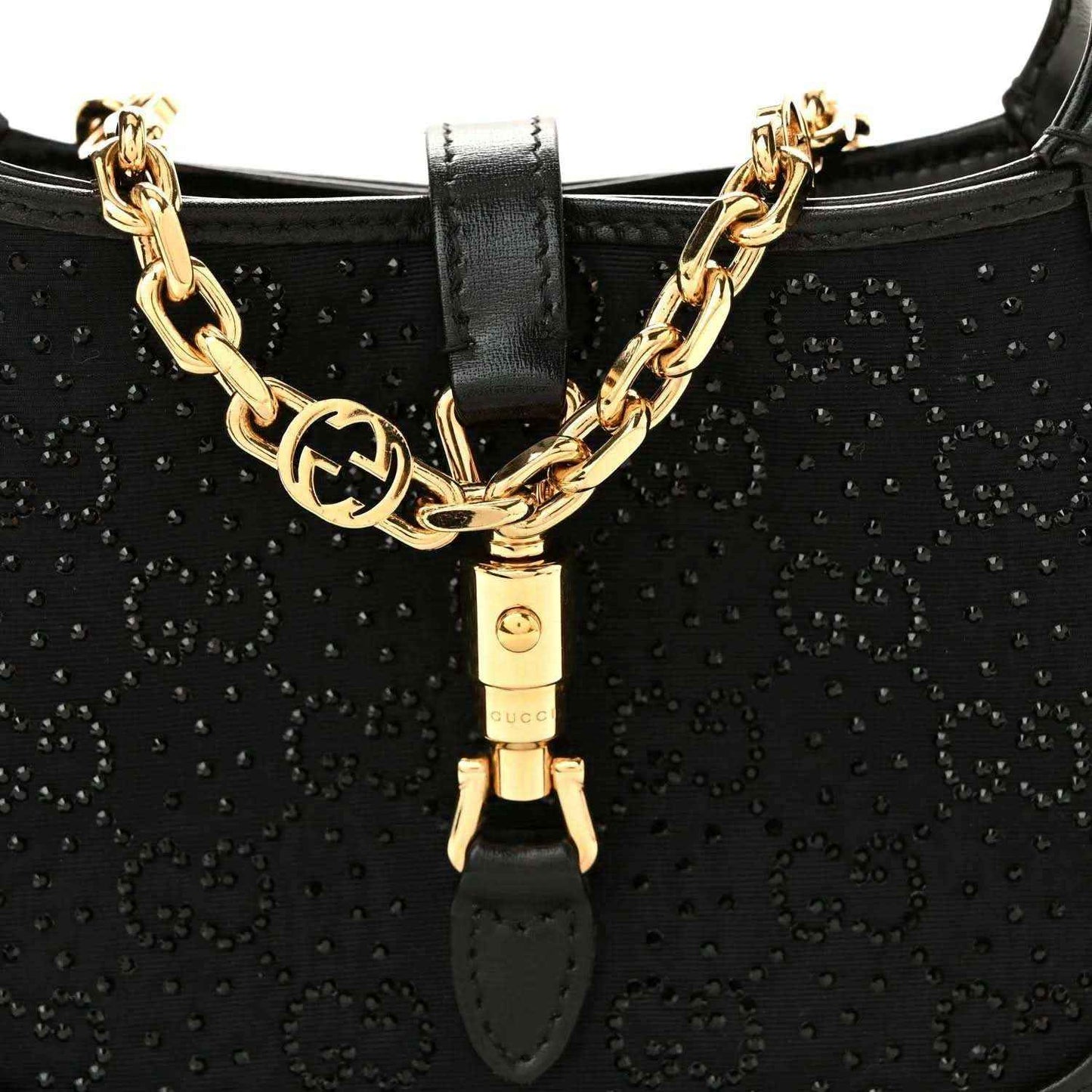 Close-up of black hobo bag front with gold chain detail and clasp hardware.