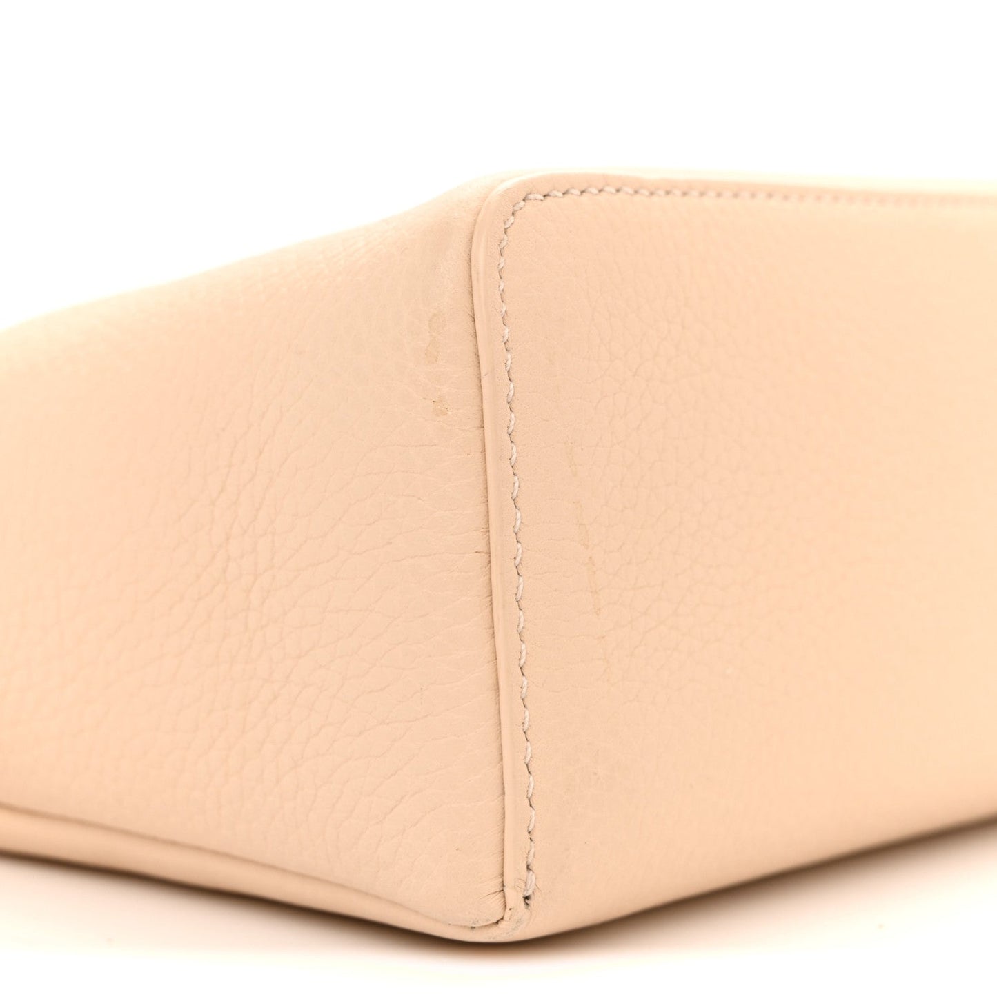 Cream grained leather pouch corner with visible contrast stitching