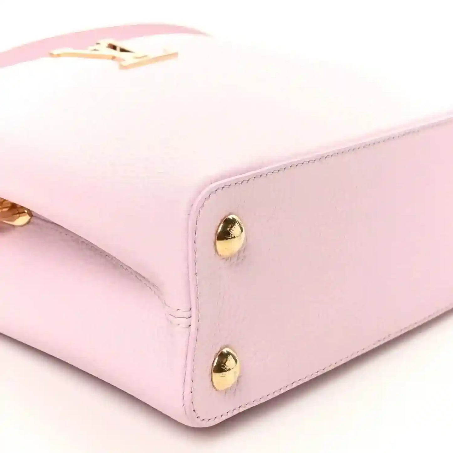 Pink leather handbag corner with gold dome studs and structured edge
