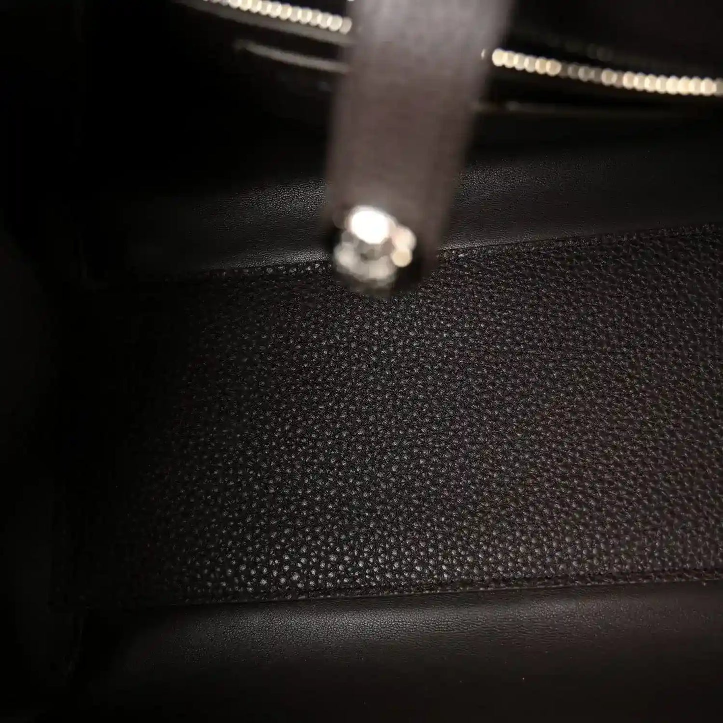 Leather bag interior with zipper track and metal pull tab