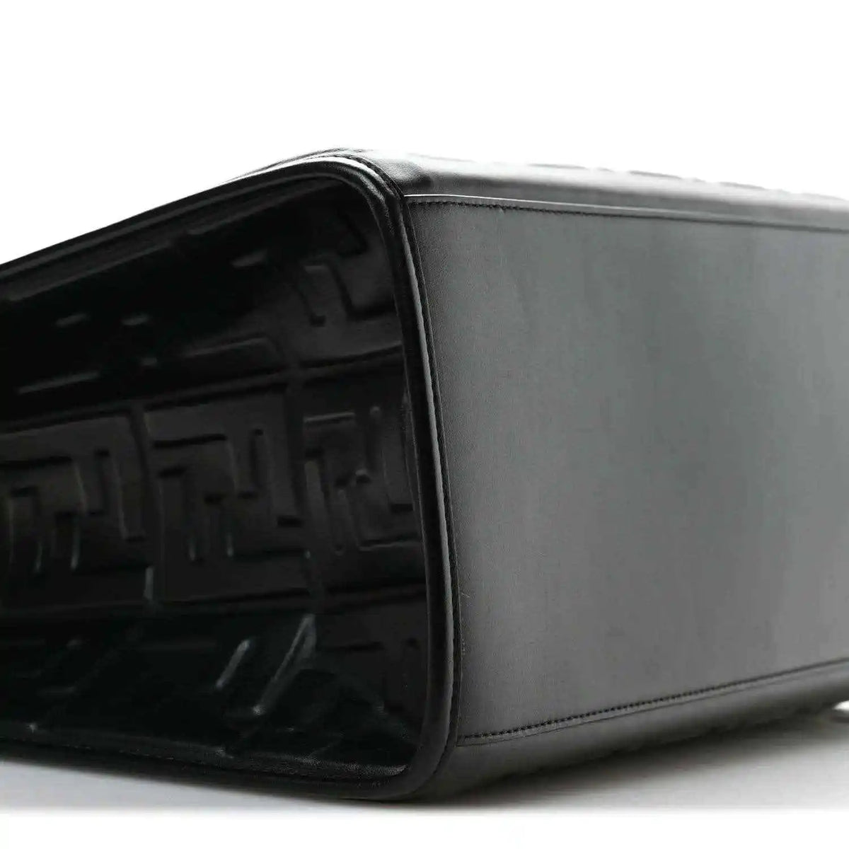Black leather tote bag side view with smooth panel and embossed FF interior