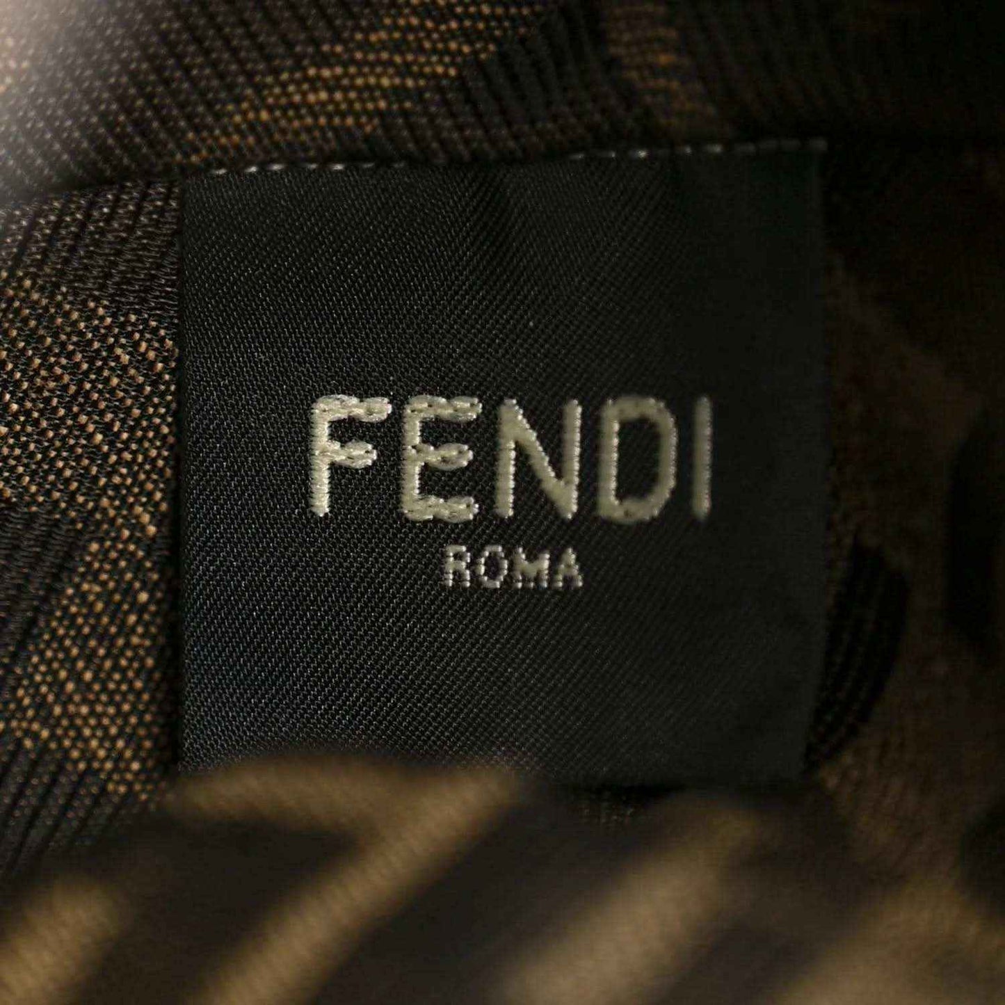 Close-up of FENDI Roma logo patch on dark bag lining.