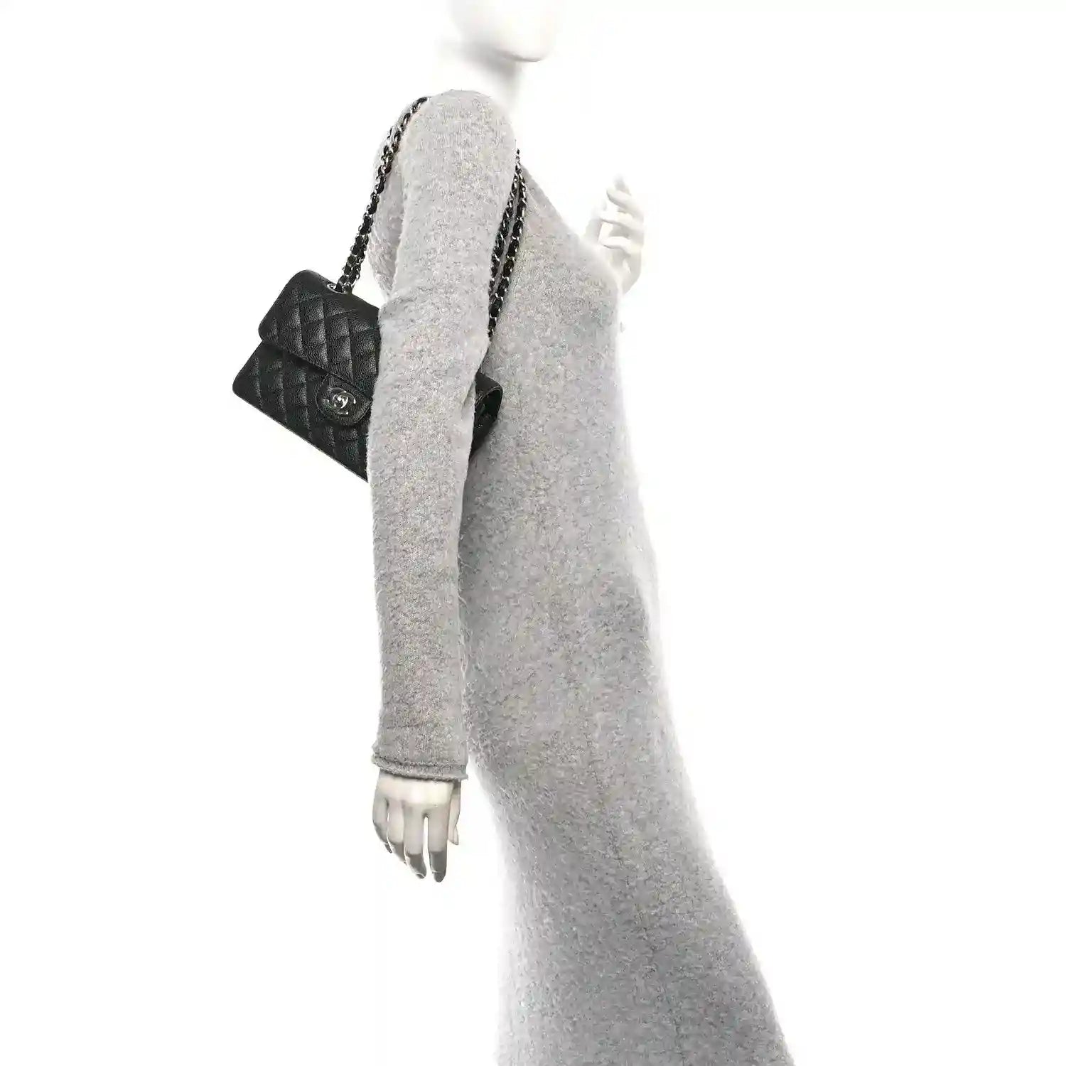 Black quilted leather double flap bag with chain strap worn on mannequin