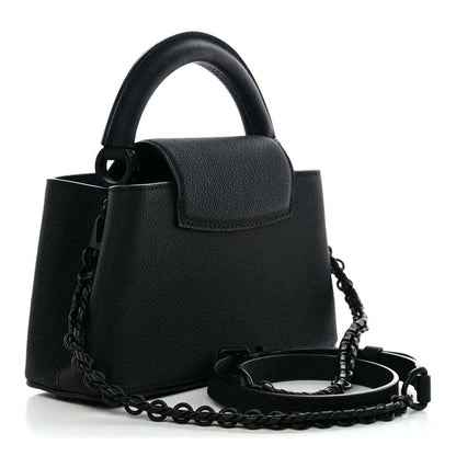 Black mini handbag with top handle, front flap, and chain shoulder strap