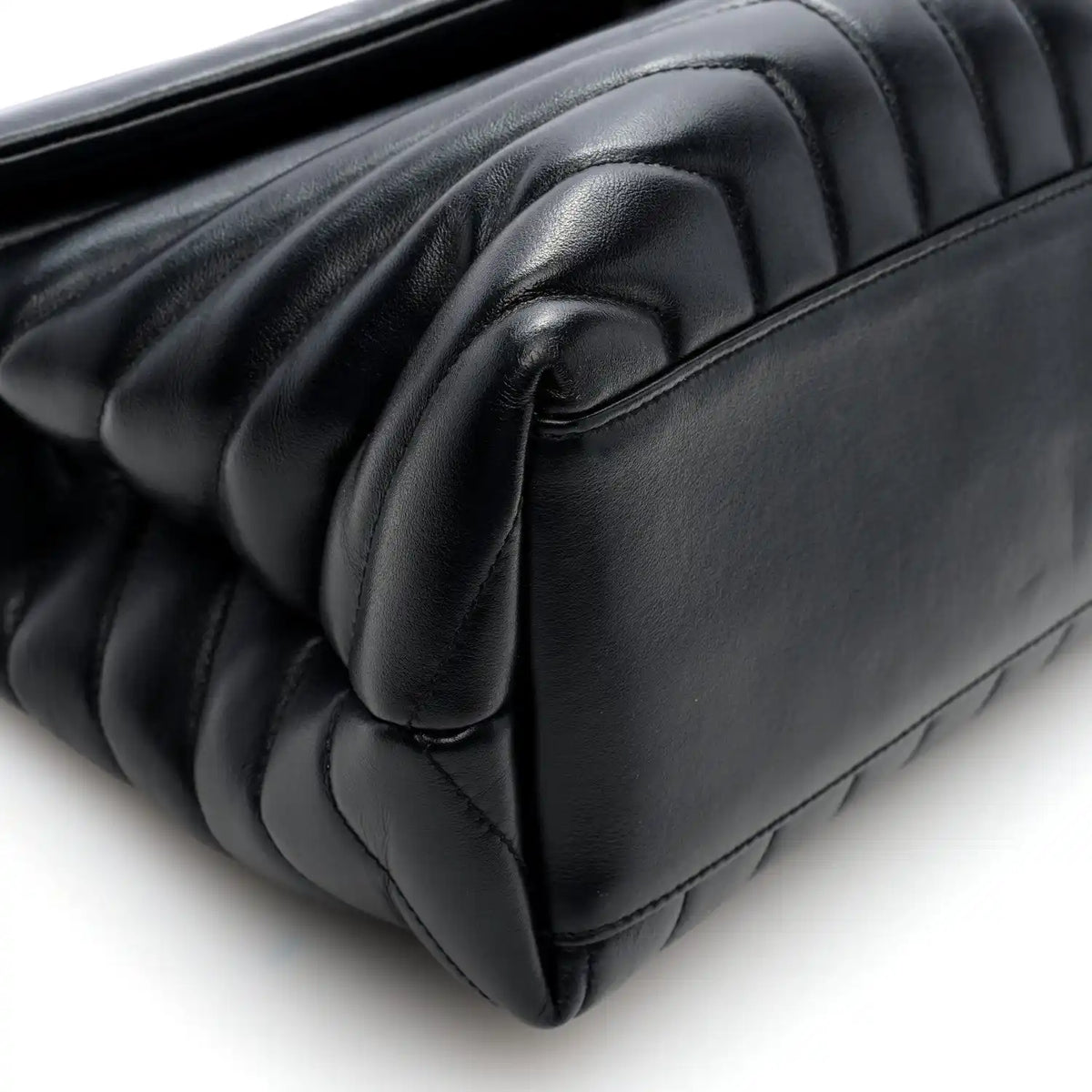 Black quilted calfskin satchel corner detail with curved flap trim