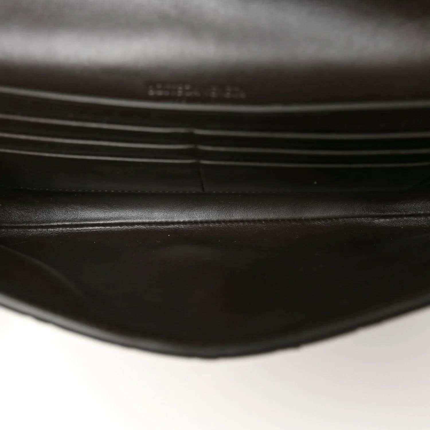 Dark leather-lined interior of a black clutch bag