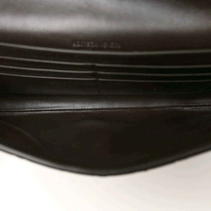Dark leather-lined interior of a black clutch bag