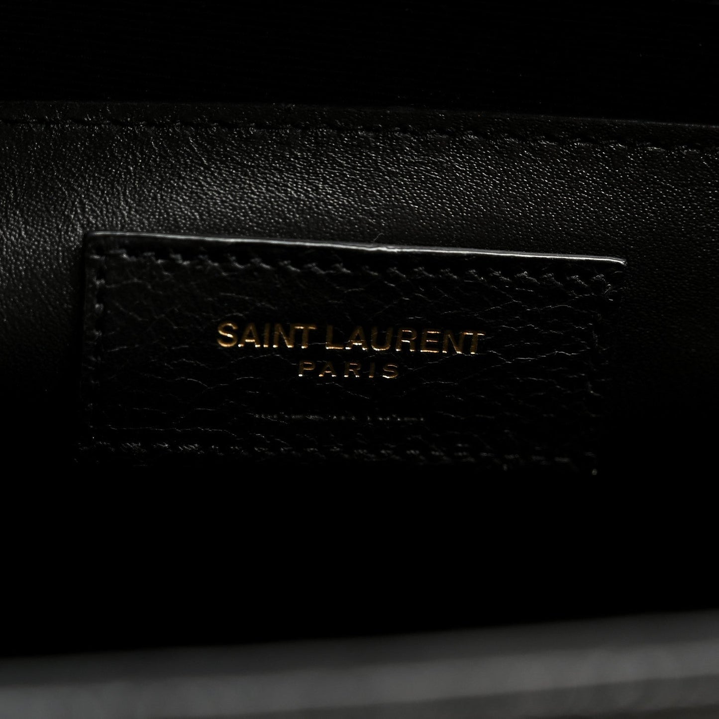 Black leather satchel with embossed “SAINT LAURENT PARIS” mark