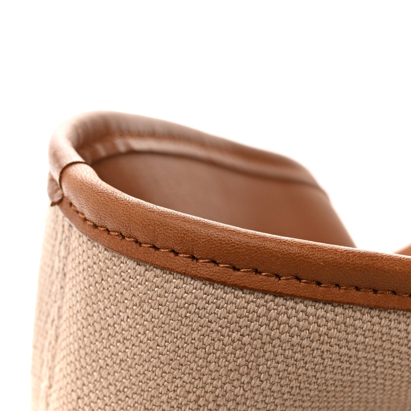Canvas tote top edge with brown leather trim and visible contrast stitching