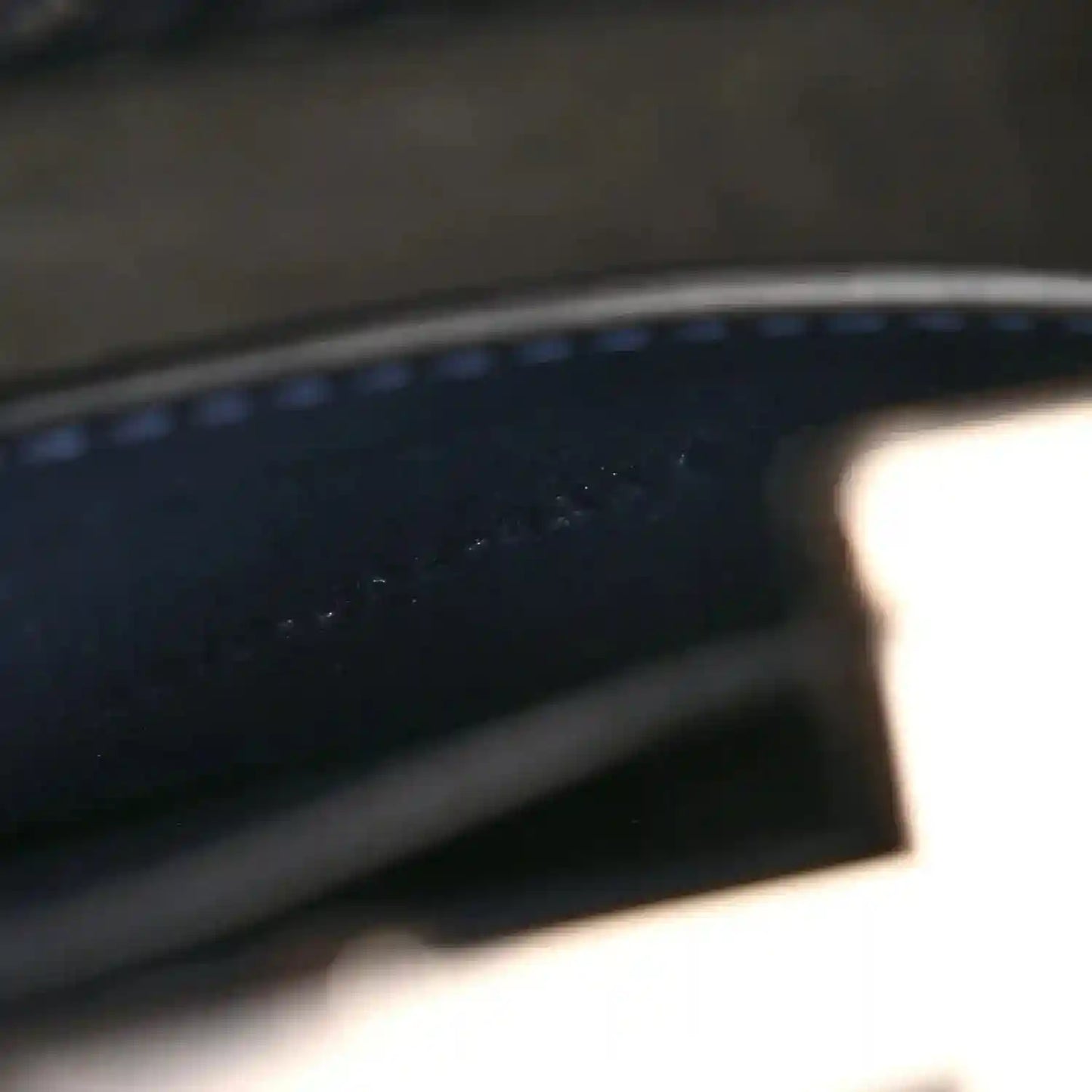 Dark leather interior edge with contrast stitching and smooth leather trim