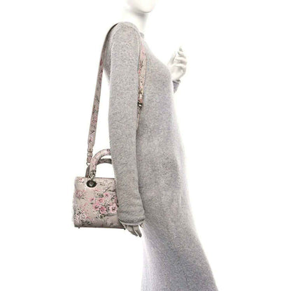 Small Lady Dior handbag side view with pink floral print and adjustable shoulder strap
