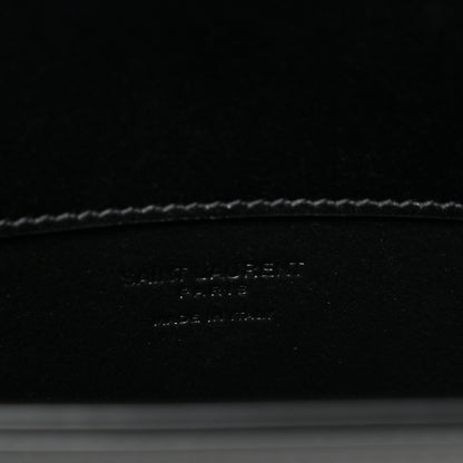Black leather crossbody bag interior base with debossed brand text and stitching.