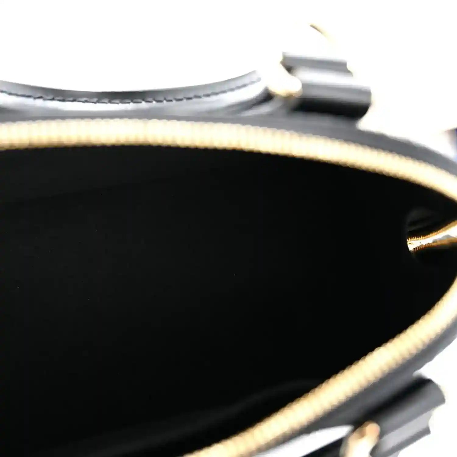 Black handbag interior edge with gold zipper track and black lining