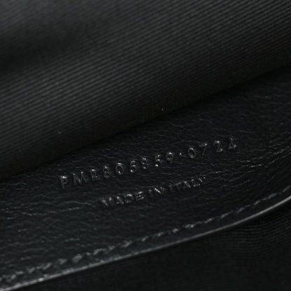 Embossed numbers on dark leather inside of Saint Laurent shoulder bag.
