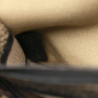 Canvas bag edge with black trim, metal rivet and strap loop hardware.