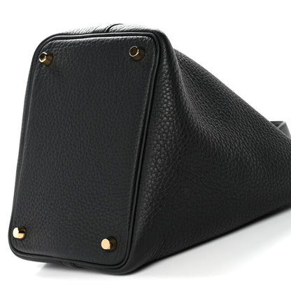 Black textured leather tote corner close-up with gold hardware and top edge