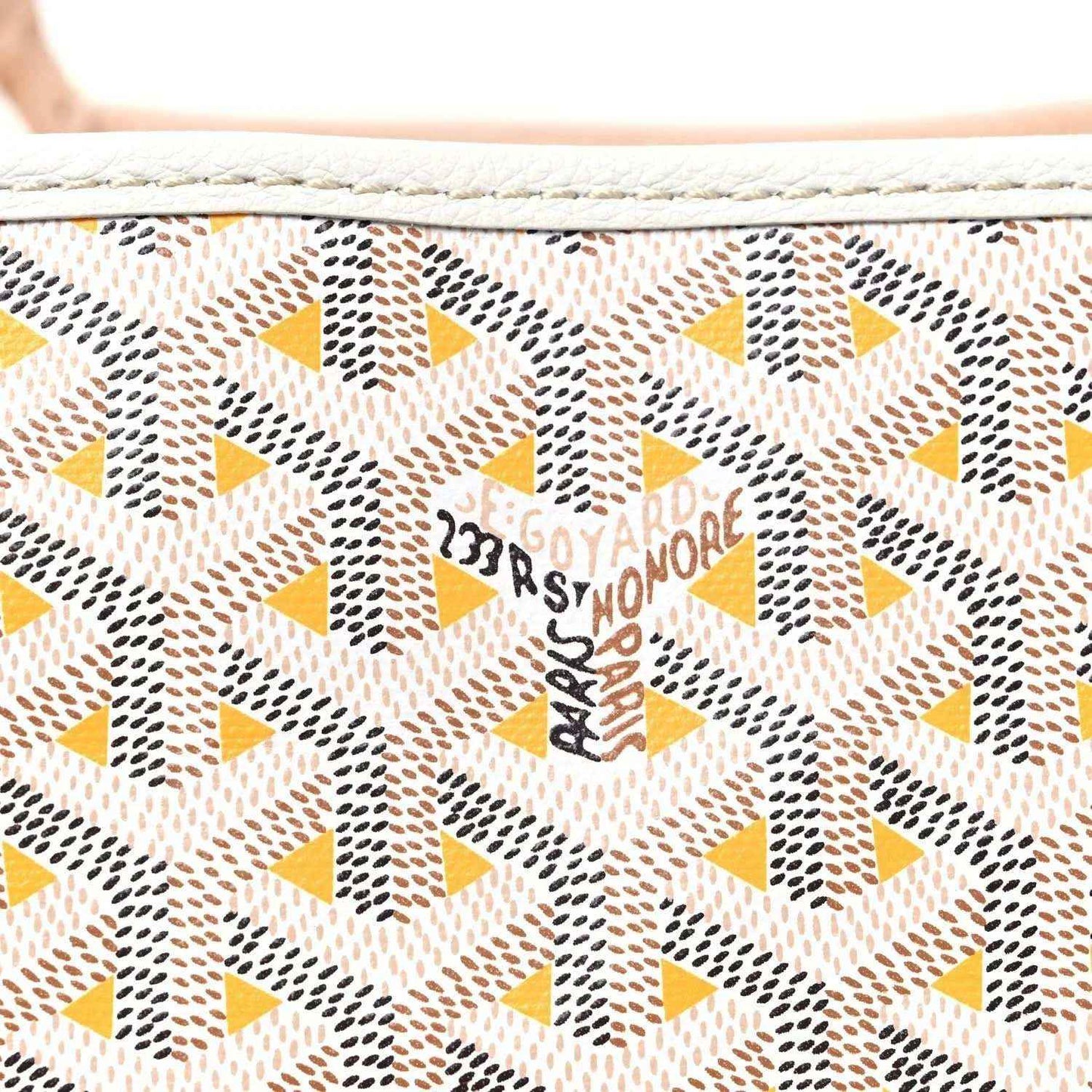 Close-up of yellow and brown star-pattern canvas with Goyardine text