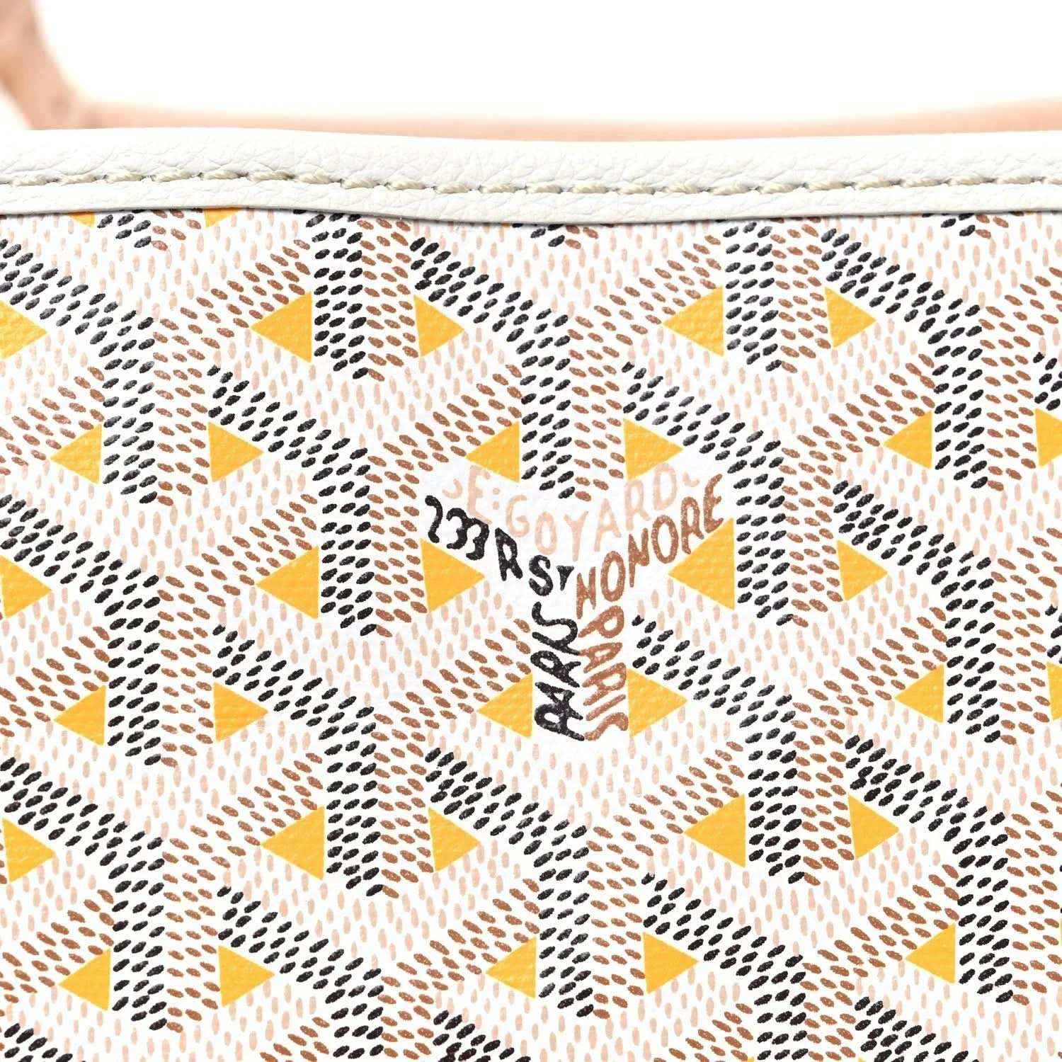 Close-up of yellow and brown star-pattern canvas with Goyardine text