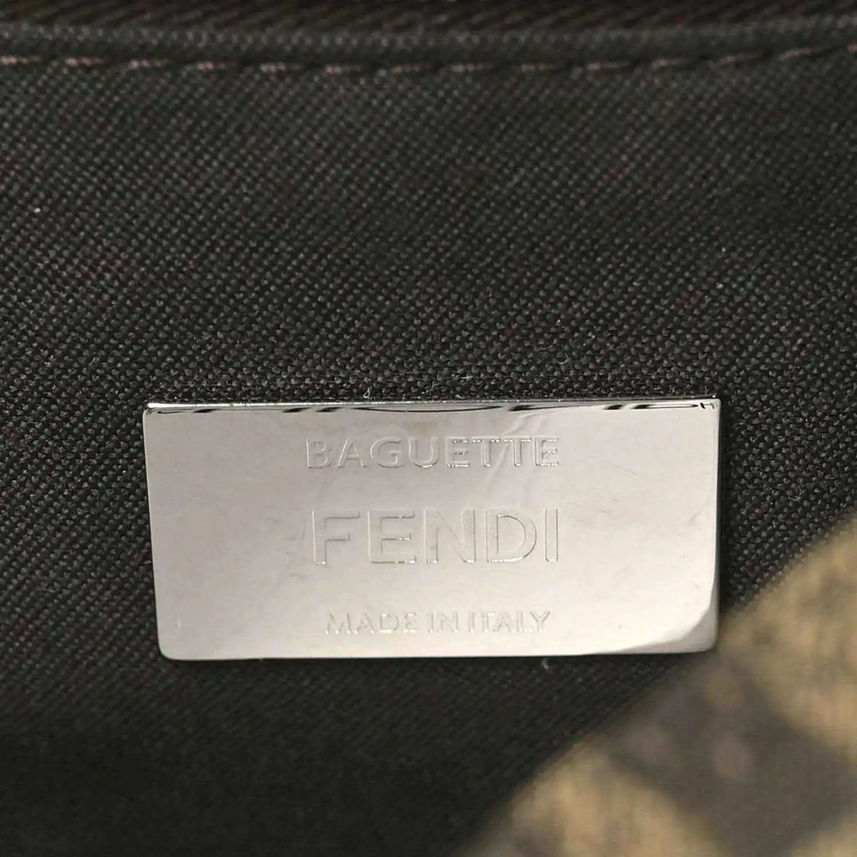 Fendi Baguette label patch on dark fabric lining, text reads FENDI MADE IN ITALY.