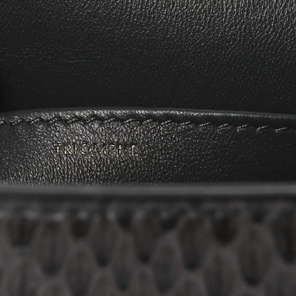 Grey snakeskin shoulder bag flap close-up with embossed brand detail