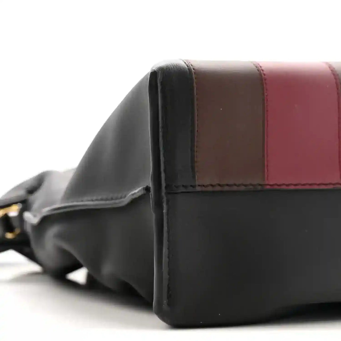 Side view of black calfskin clutch with burgundy leather trim
