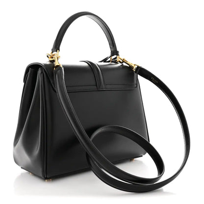Black small top-handle satchel with long crossbody strap and gold-tone hardware