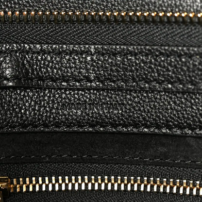 Black grained leather with “MADE IN ITALY” stamp and gold zipper trim