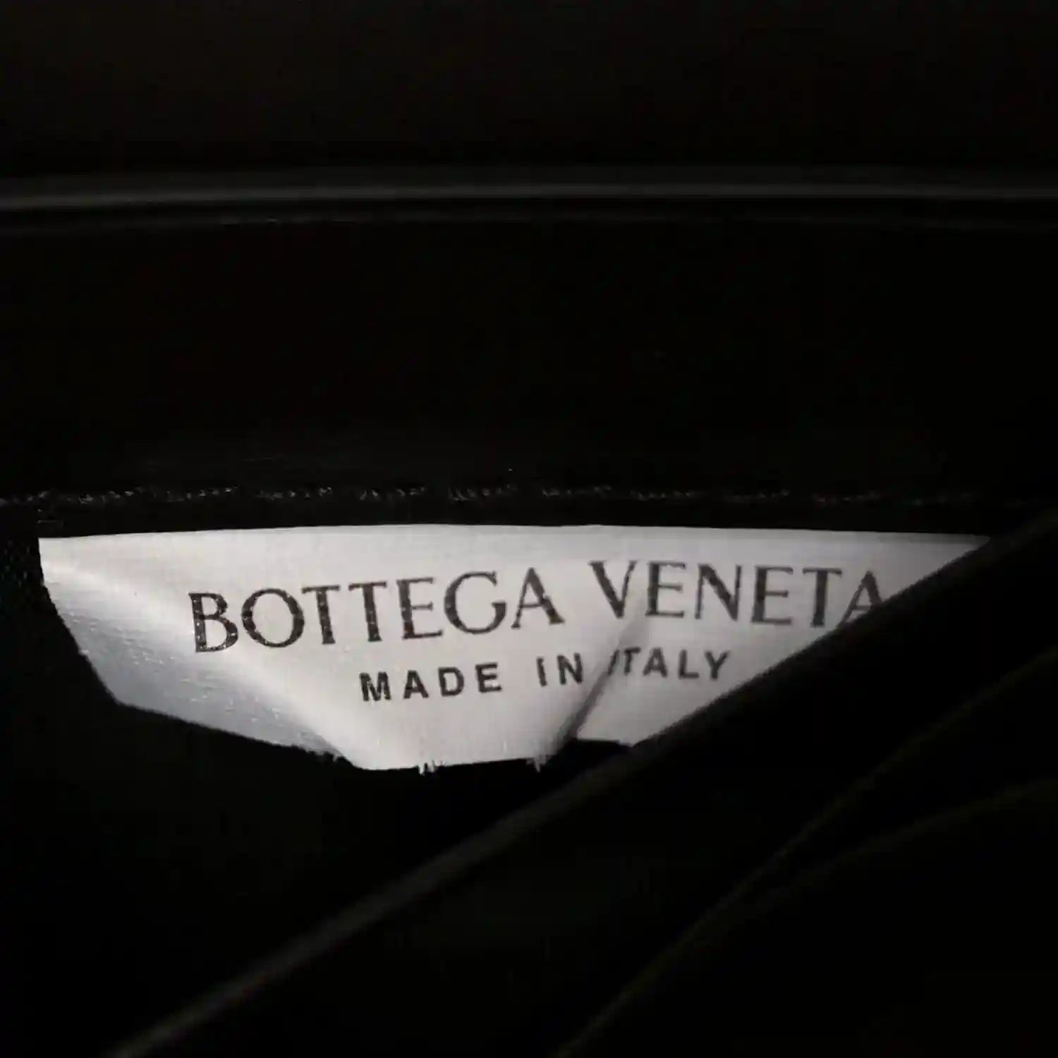 Bottega Veneta Made in Italy label inside dark leather clutch