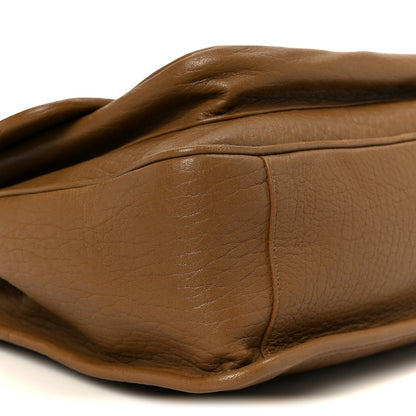 Grained leather satchel in dark cork with curved seam and smooth panels.