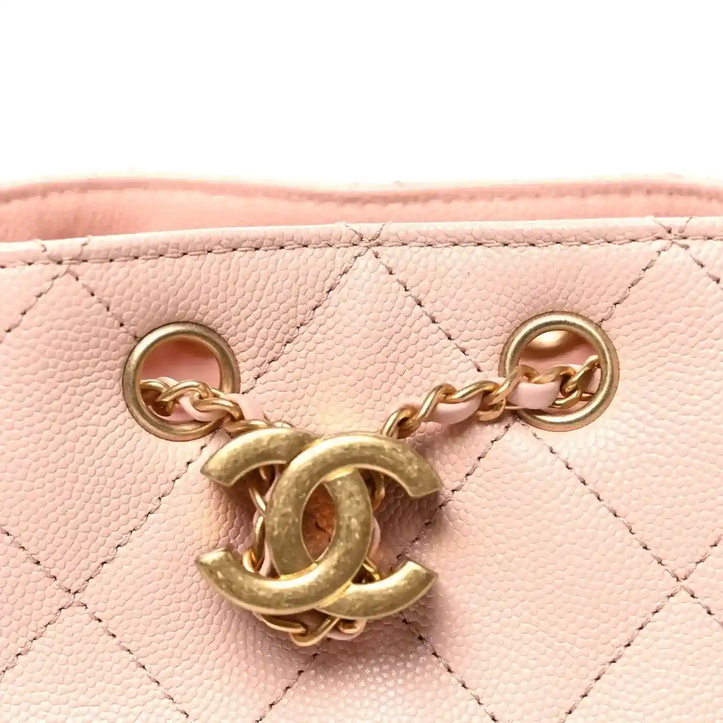 Gold-tone Chanel-style charm and chain attachment on quilted pink bag
