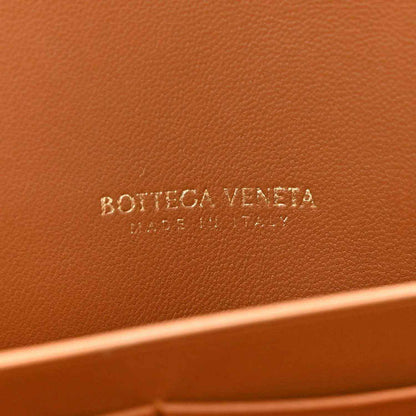 Amber suede clutch with embossed “BOTTEGA VENETA” logo on inner panel