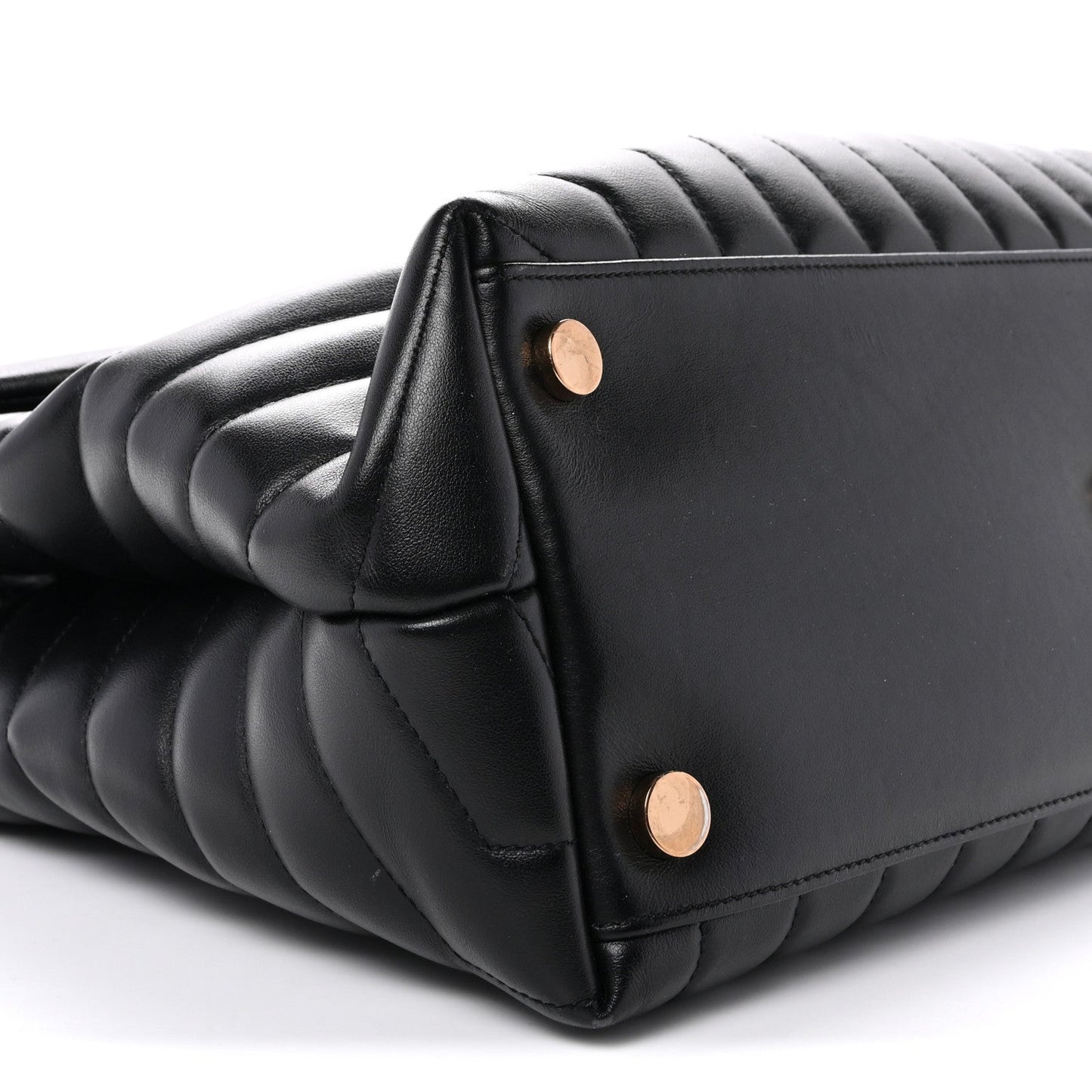 Black quilted satchel corner with gold snap buttons and curved side seam
