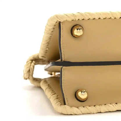 Petite raffia satchel bag side view with tan leather flap and gold snap buttons.