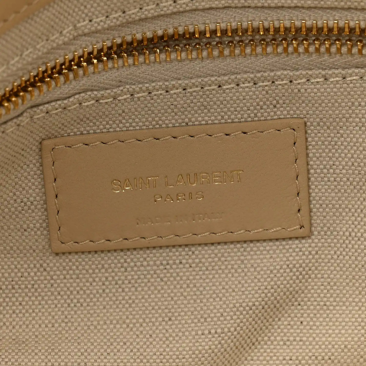 Beige interior leather label reading SAINT LAURENT PARIS with stitched border