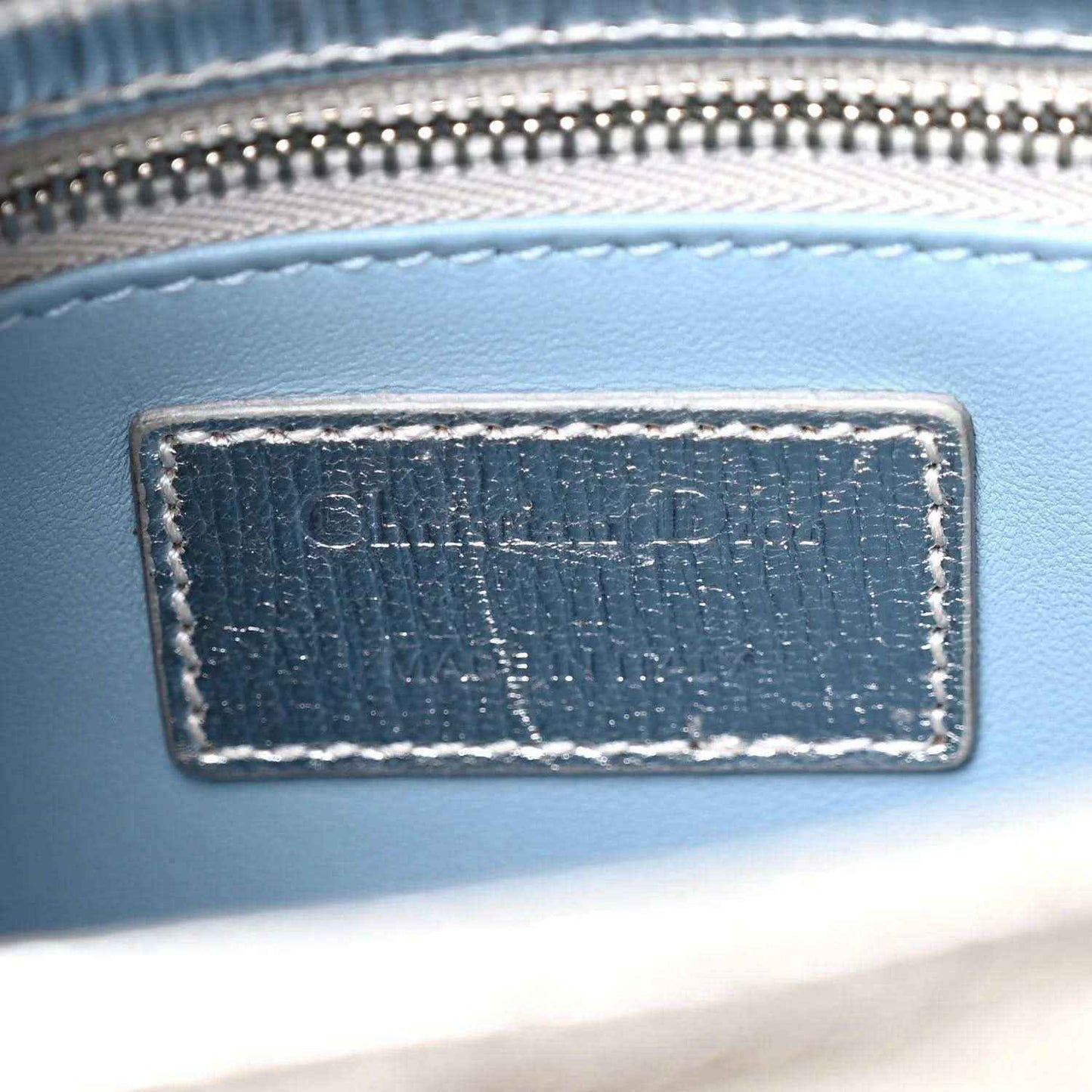 Christian Dior label patch on blue leather bag