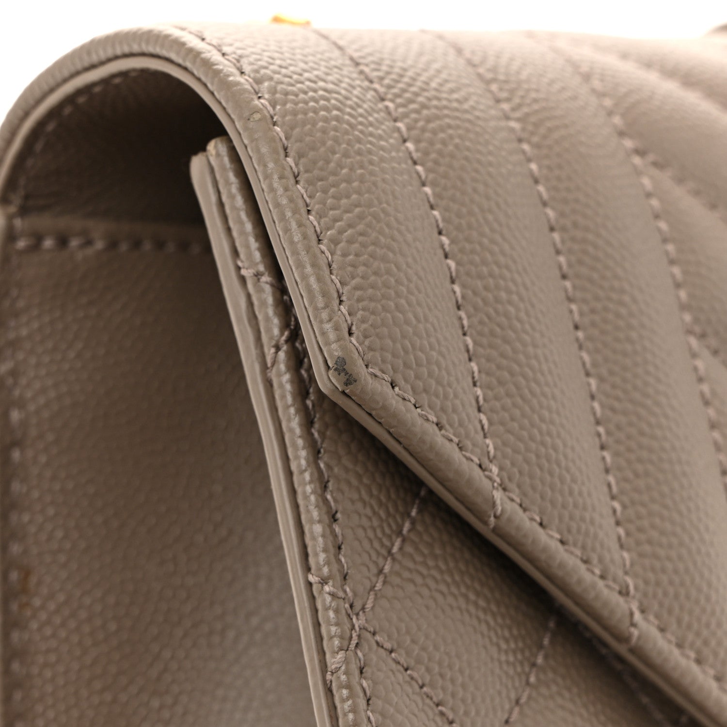 Satchel strap edge with textured leather and stitched trim