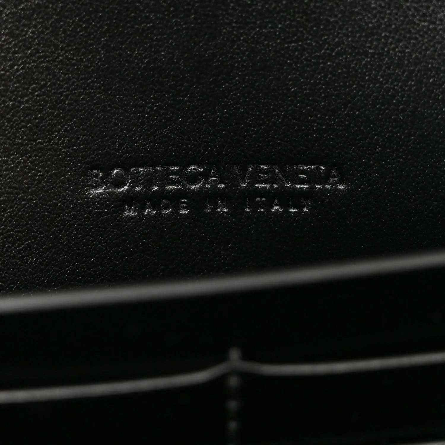 Bottega Veneta leather clutch brand imprint on black leather
