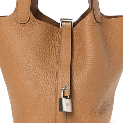Biscuit leather bucket bag with metal lock and stitched strap