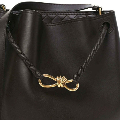 Small bucket bag in dark leather with braided side detail and gold-tone clasp